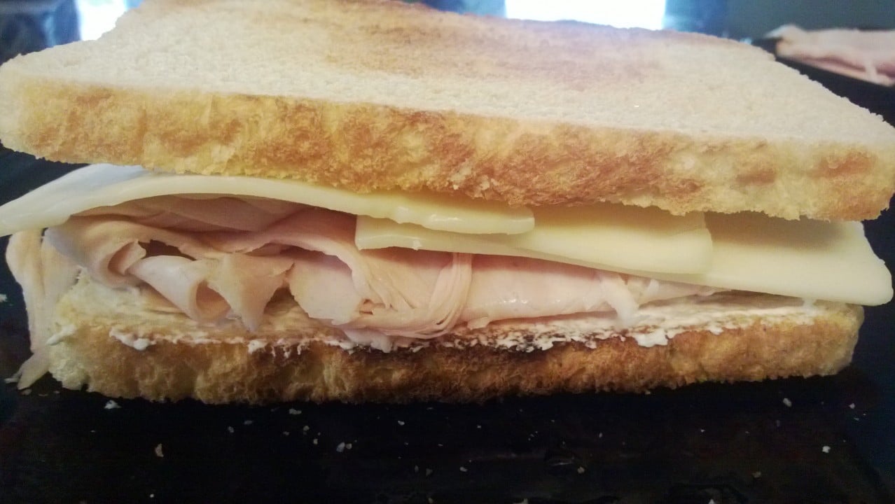 A sandwich with turkey and cream cheese on a plate.