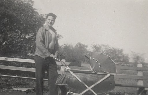 Vintage man walking baby in stroller. 