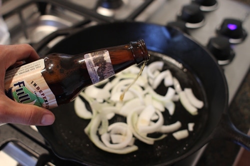 Vintage cooking onions in dark ale until onions are reduced and very sloppy.
