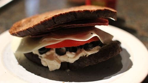 A Month of Sandwiches featuring Great-Grandpa's Salami Sandwich, served on a plate with meat and cheese.