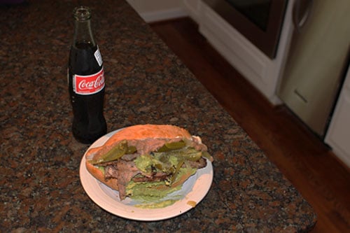 Served sandwich over a plate with coca cola.