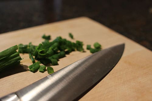 Vintage chop green onion and knife placed at table.