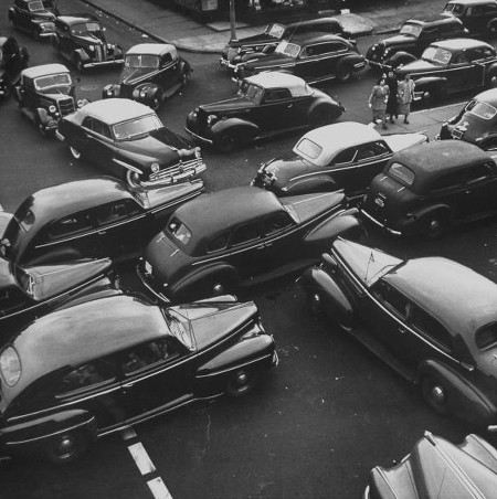 Vintage cards in gridlock at intersection mid 20th century.