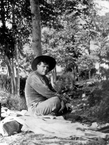 Vintage man sitting and looking his right side waring hat.