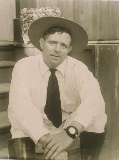 Vintage man in white shirt and wearing hat looking at front.