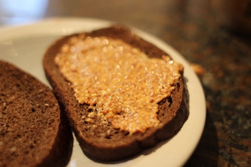 Vintage german mustard to one slice of pumpernickel.