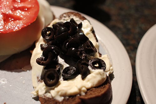 Vintage sliced olives and black pepper on plate.