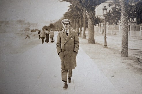 Solvitur Ambulando - A man in a coat walking down a sidewalk.