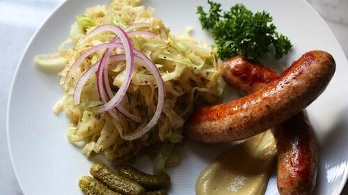 A low carb dish with sausage, pickles and sauerkraut.