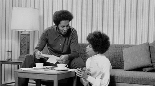 A black and white photo capturing the tranquil moment of a couple sitting on a couch, showcasing their need for communication in their relationship.