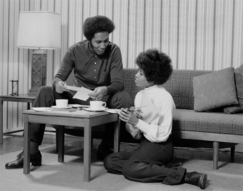 A black and white photo capturing the tranquil moment of a couple sitting on a couch, showcasing their need for communication in their relationship.