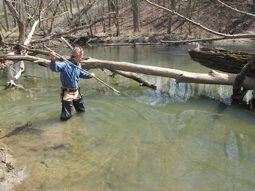 Man using small gig spear in river. 