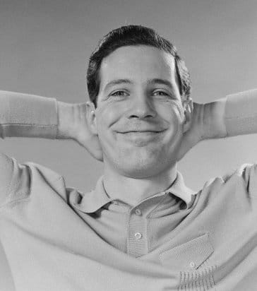 Vintage man in polo shirt smiling hands behind head.