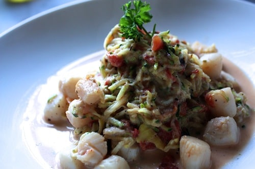 Bay scallop scampi and zucchini pasta served with sauce.