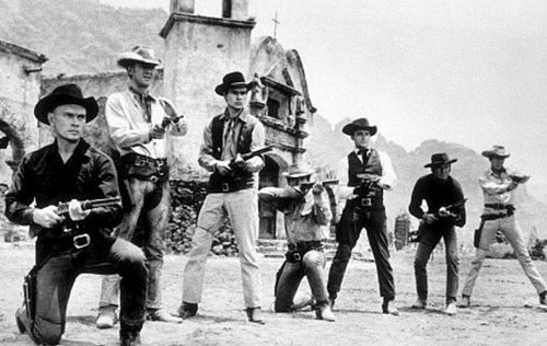 Magnificent seven old western movie film group aiming runs rifles.