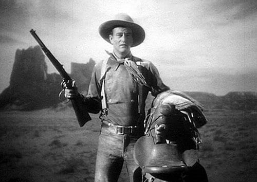 Stagecoach old western movie film john wayne with rifle.