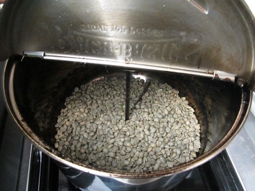 Roasting green coffee beans in popcorn popper on grill. 