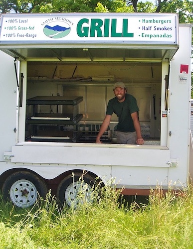 Fast food truck with person standing inside.