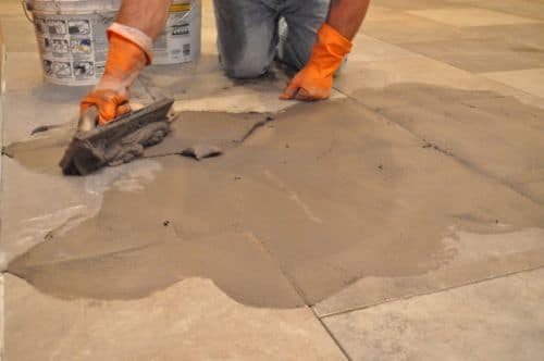 Using grout float to get grout into tile joints. 
