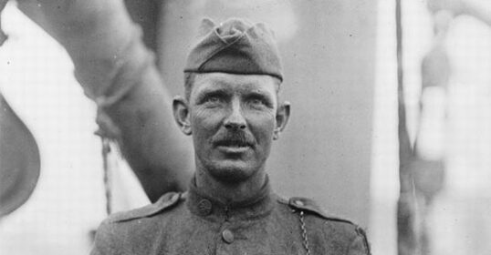 Sergeant Alvin C. York, a man in uniform, standing in front of a ship after making a difficult decision.