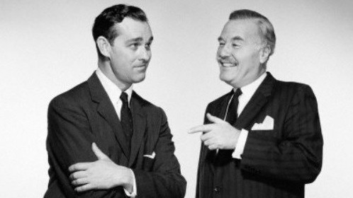 Two men in suits, confidently accepting a compliment.