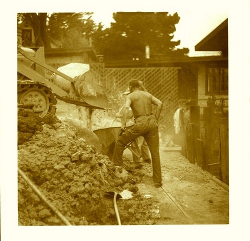 vintage men working on construction site hauling stones   
