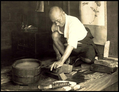 Vintage swordsmith working on curved blade.