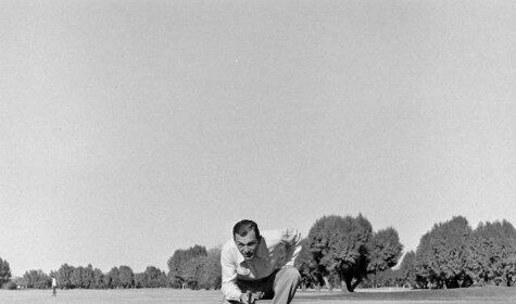 An old black and white photo of a man putting a golf ball, highlighting his strength.