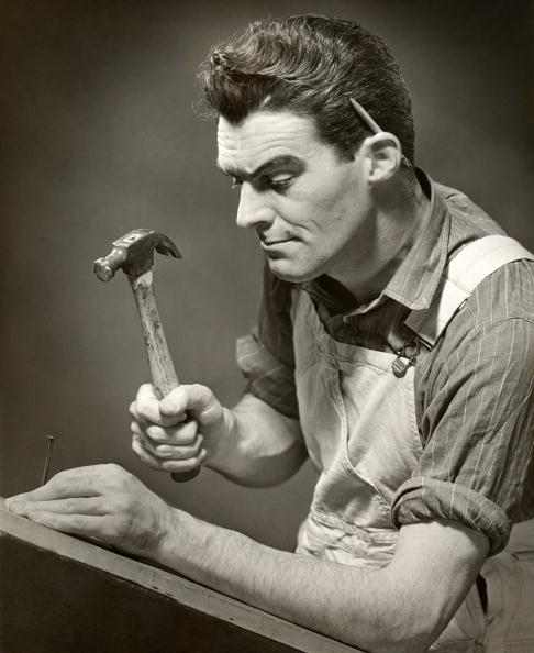 Vintage carpenter hammering a nail.