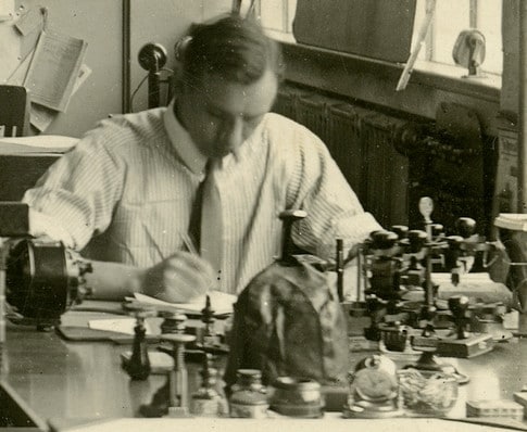 Vintage scientist taking notes at laboratory lab table.