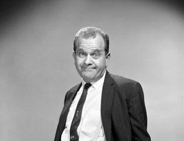 A black and white photo of a man in a suit, showcasing elegance and sophistication.