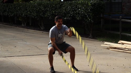 Vintage man moving His double arm for alternating waves + squat.