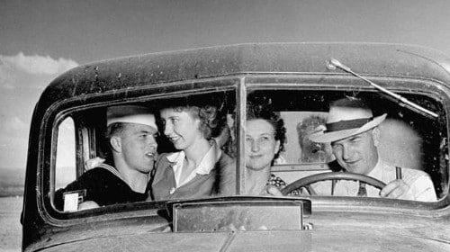 A smooth group of people bringing their girlfriend, sitting in the back seat of a car.