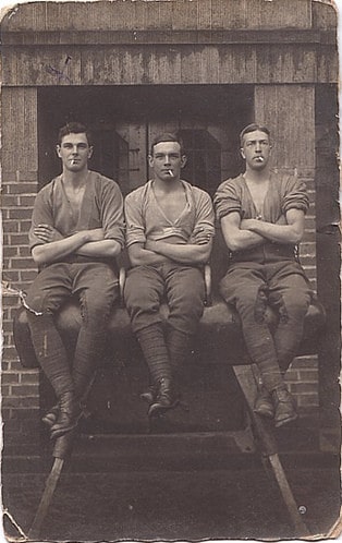 Vintage photo three men sitting posing with cigarettes.