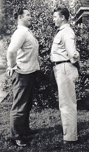 Vintage photo two men friends puffing chests out with cigars.