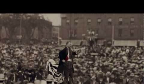 A strong as a bull moose man in a suit standing in front of a crowd, embodying moments in manliness.