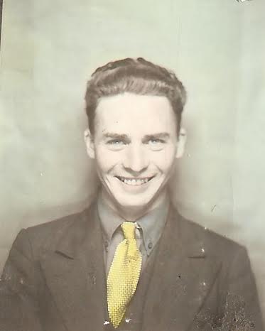 Bob Lynes vintage young man portrait chest up suit and tie big smile.