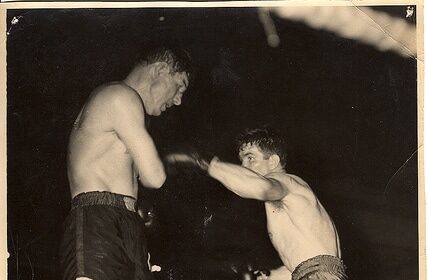 Two men engaged in the sweet science of boxing in a ring.