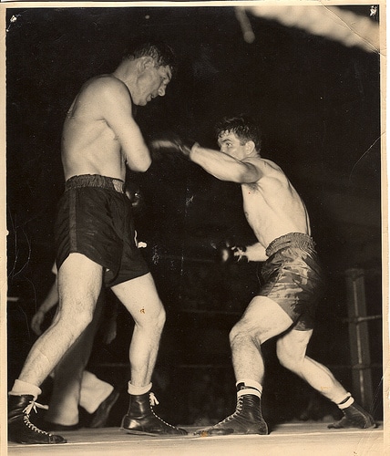 Two men engaged in the sweet science of boxing in a ring.