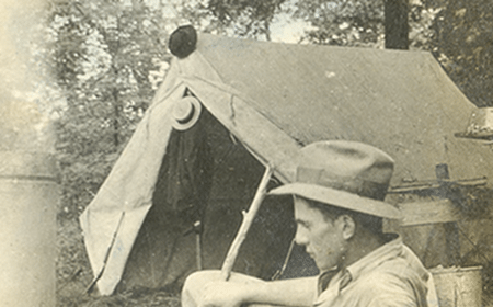 A man camping near a tent.