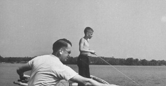 A father and son enjoying the best activity of fishing together in a small boat.