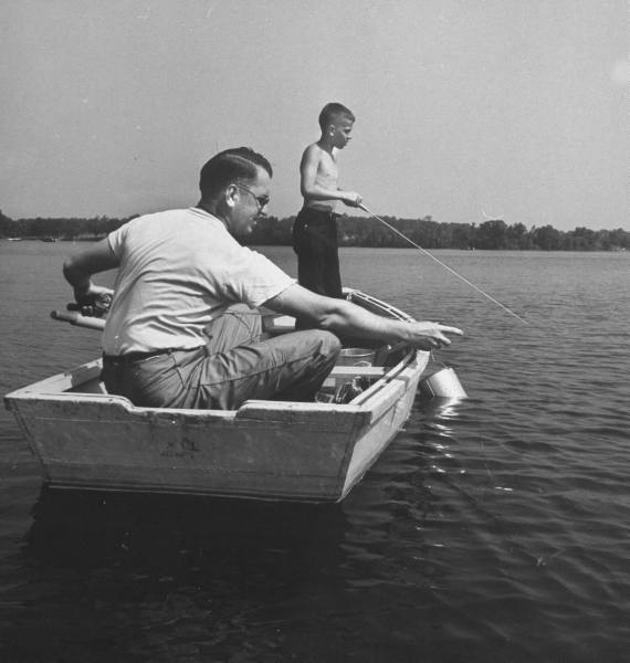 A father and son enjoying the best activity of fishing together in a small boat.
