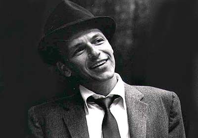 A black and white photo of a man in a suit and tie, reminiscent of Frank Sinatra.