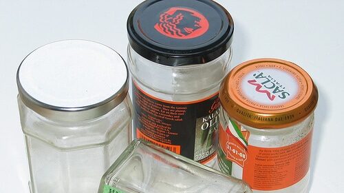 Glass jars with lids stuck on a white surface.