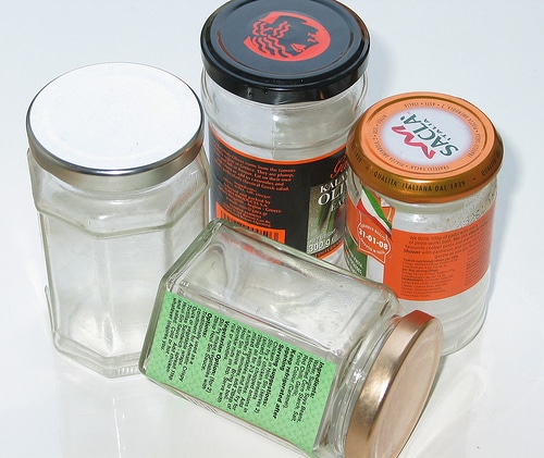 Glass jars with lids stuck on a white surface.
