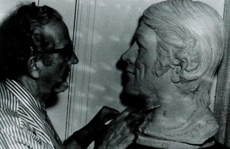 An old black and white photo of a man working on a modern bust.