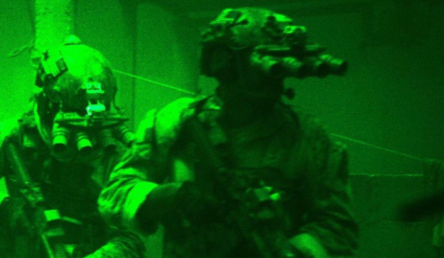 A group of soldiers in camouflage gear in a dark room pulling an all-nighter.