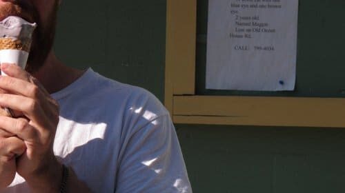 A bearded restaurant critic enjoying an ice cream cone.