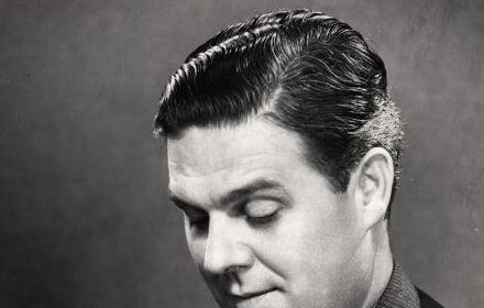 A punctual man in a suit looking at his watch.