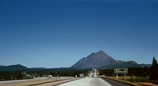 Embark on a great American road trip as you drive across the country, with a majestic mountain in the background.